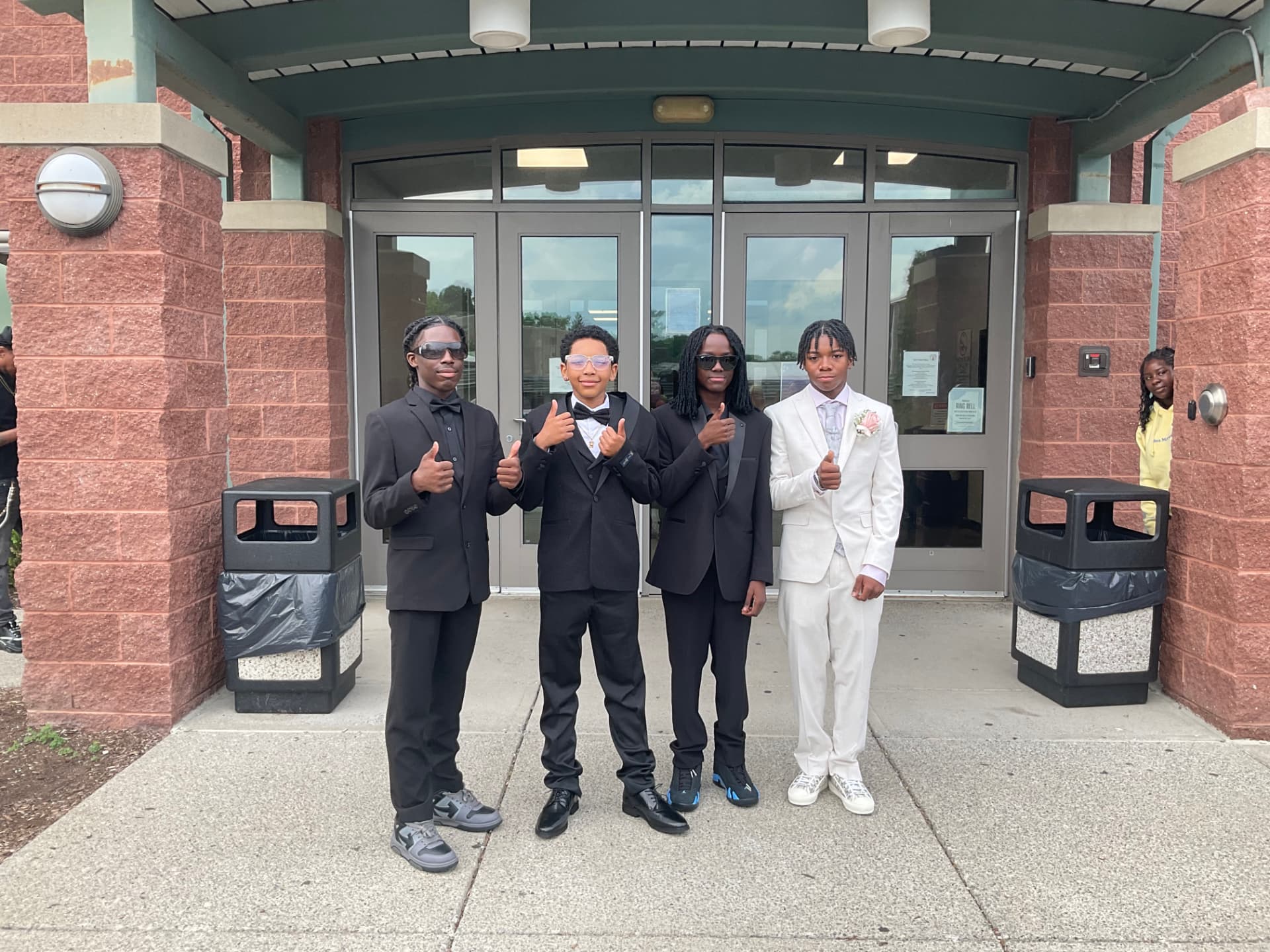 Green Tech Charter School students giving a thumbs up in formal attire at the entrance