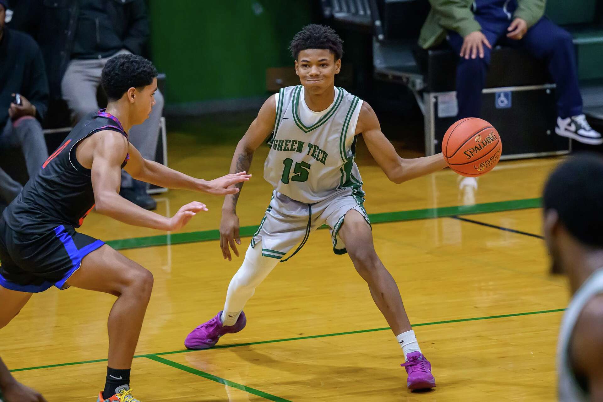 Green Tech Charter School Eagles guard in a white jersey handling the ball against a defender during a home game in Albany, NY